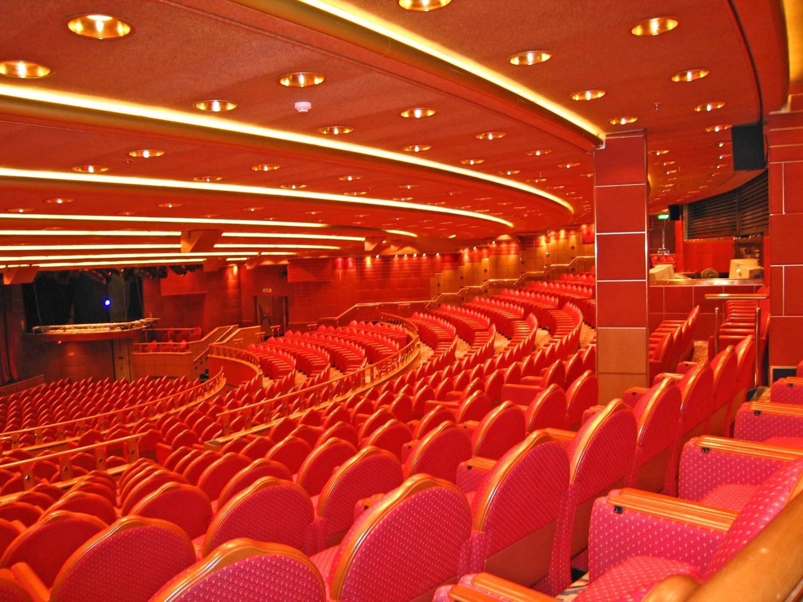 A large auditorium with red seats and lights.